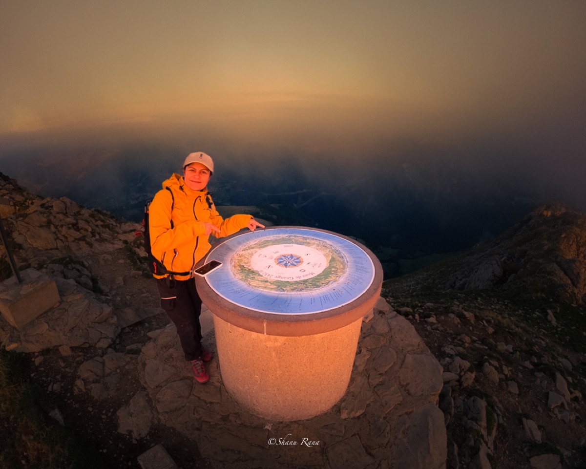 Shanu at the Mont de Grange summit marker at dusk